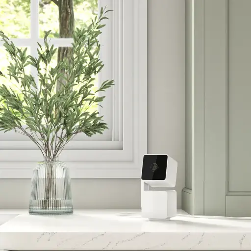 3D white background render showcasing a security camera on a marble surface next to a vase with green foliage.