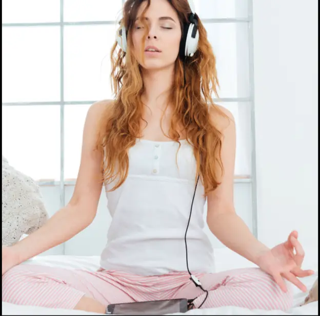 A person meditating with headphones in a peaceful setting, showcasing lifestyle photography.