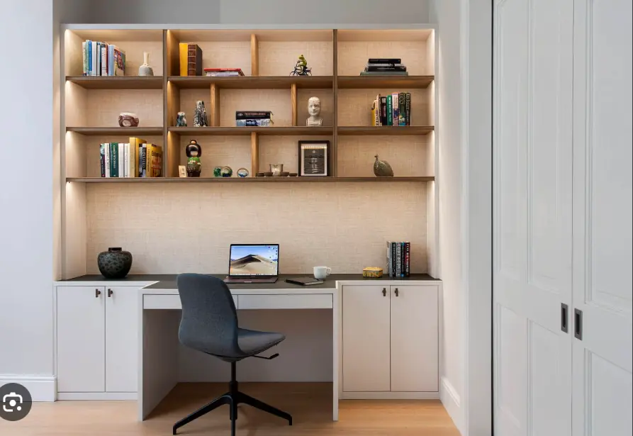 A modern home office setup with a desk, bookshelves, and a laptop, featured in lifestyle photography.