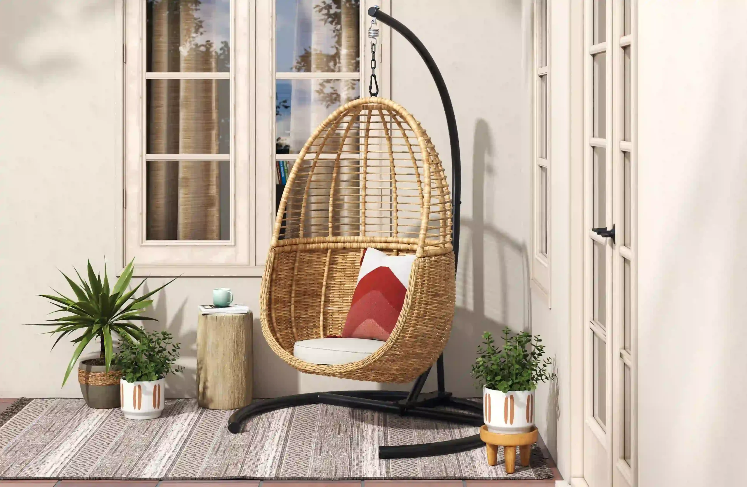 3D rendering of a wicker egg chair on a patio with potted plants and natural lighting